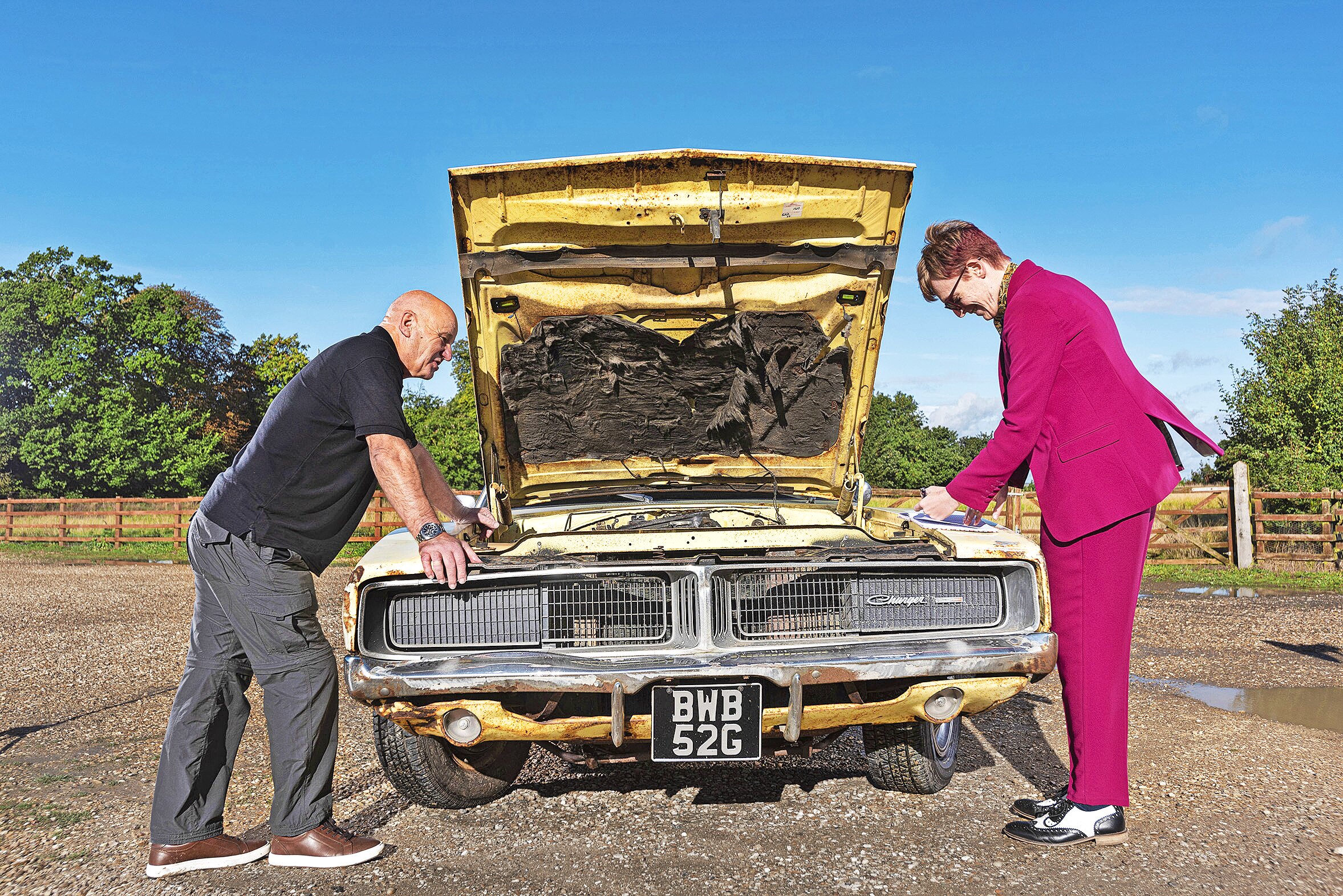 two people looking under the bonnet of the Dodge Charger