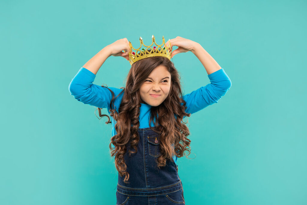 A young girl with a crown on her head.
