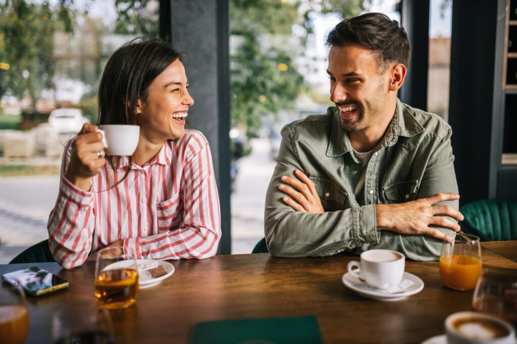 A man and a woman drink coffee in a cafe together