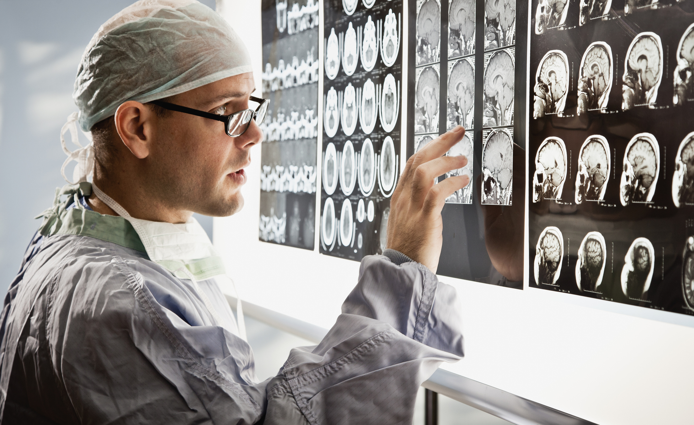 Doctor in surgical wear examines mri scan