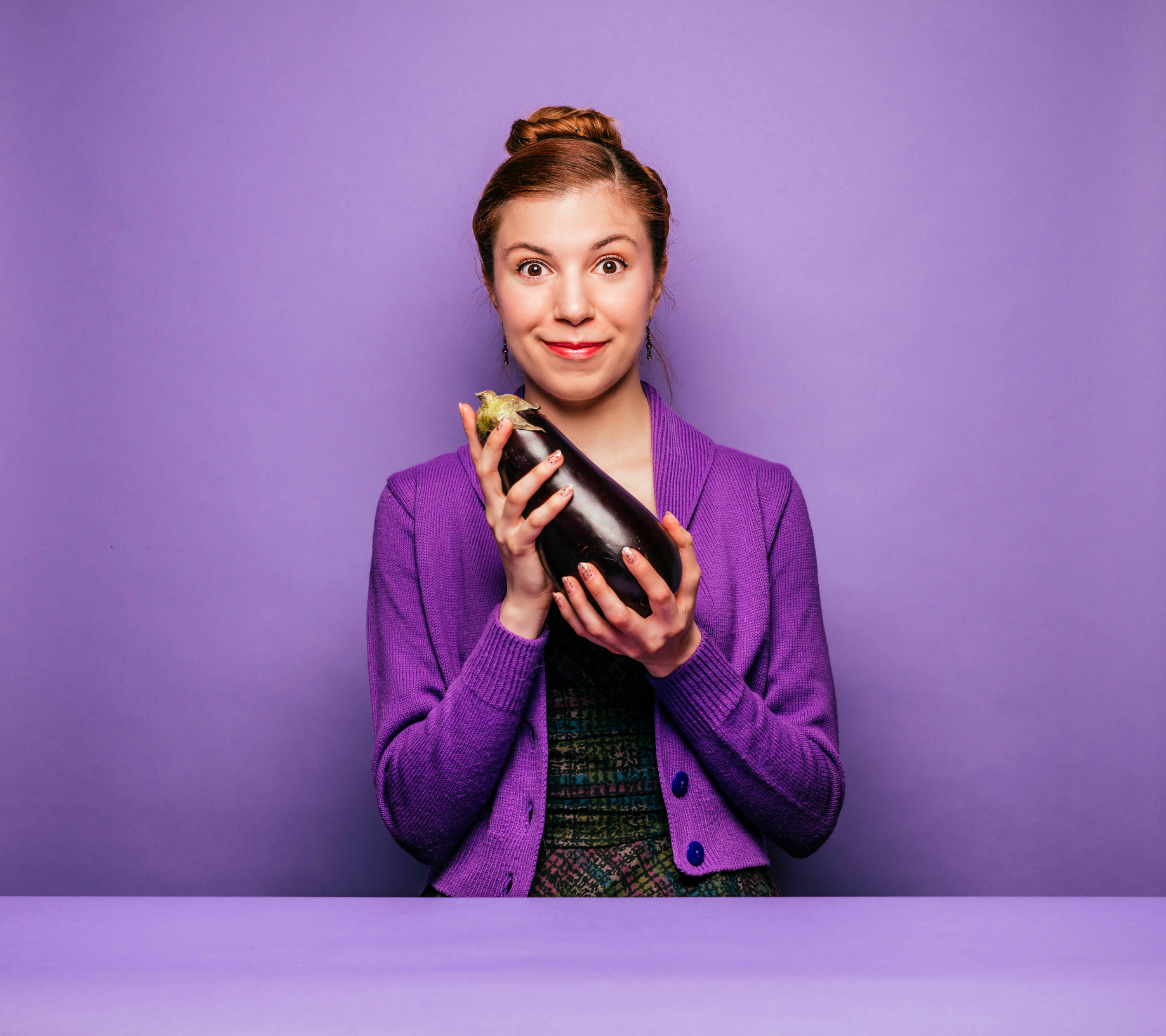Young woman holding an eggplant