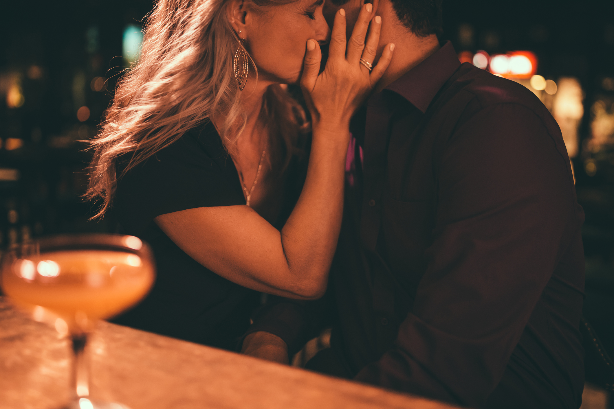 Elegant mature couple kissing on romantic date night at bar