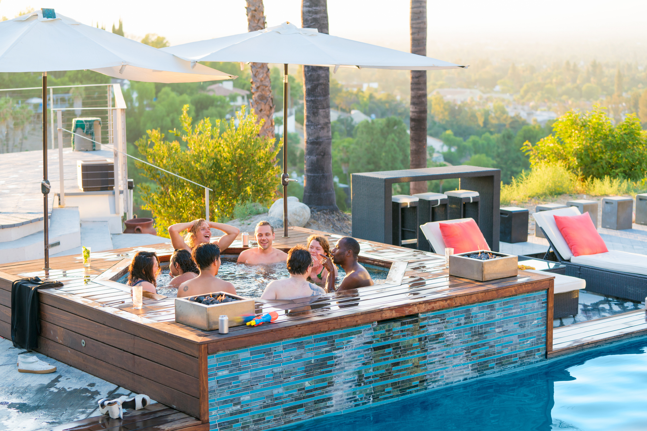 Friends relaxing in a luxury hot tub outdoors at sunset