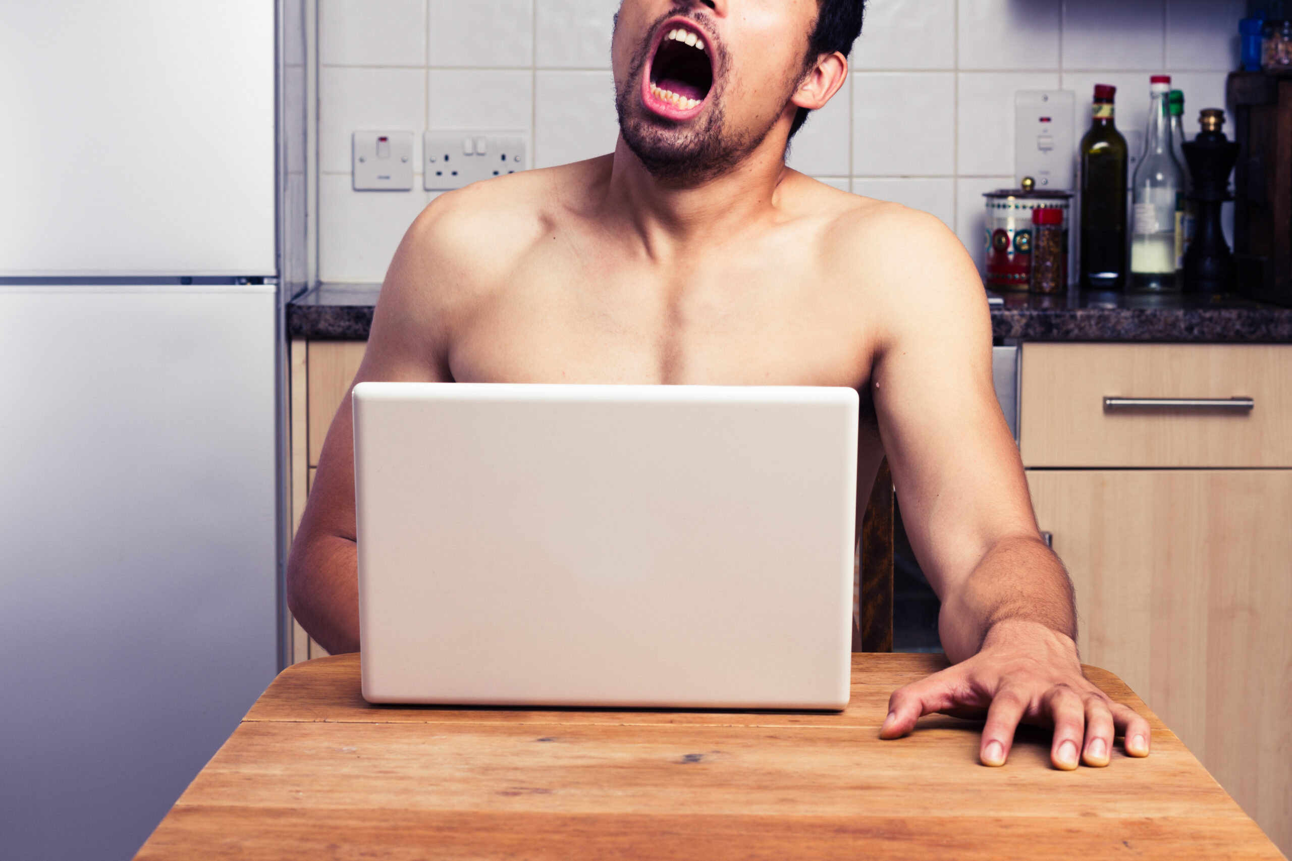 RECORD DATE NOT STATED Young man is watching pornography on his laptop in the kitchen