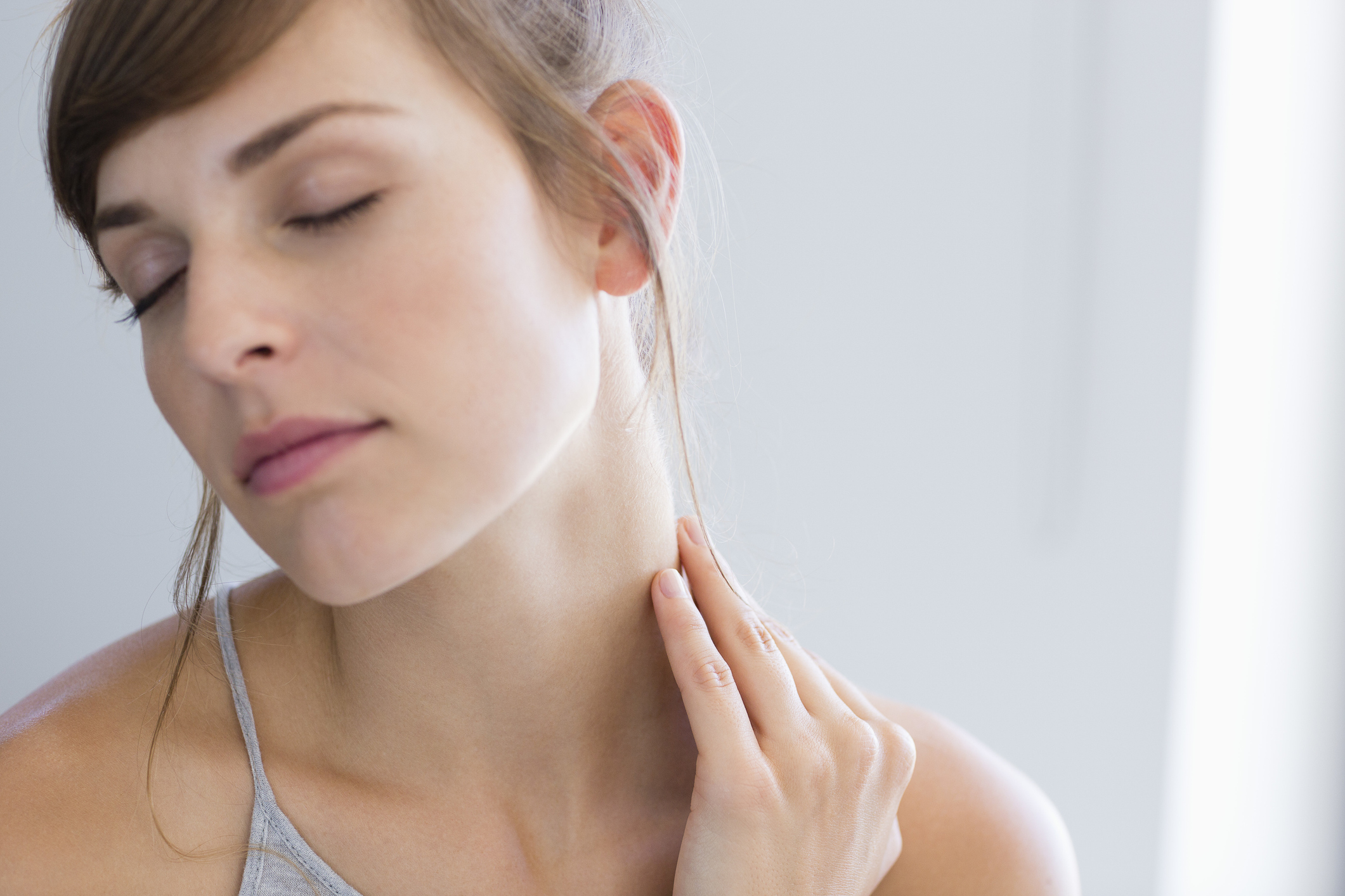 Close-up of a beautiful woman massaging her neck