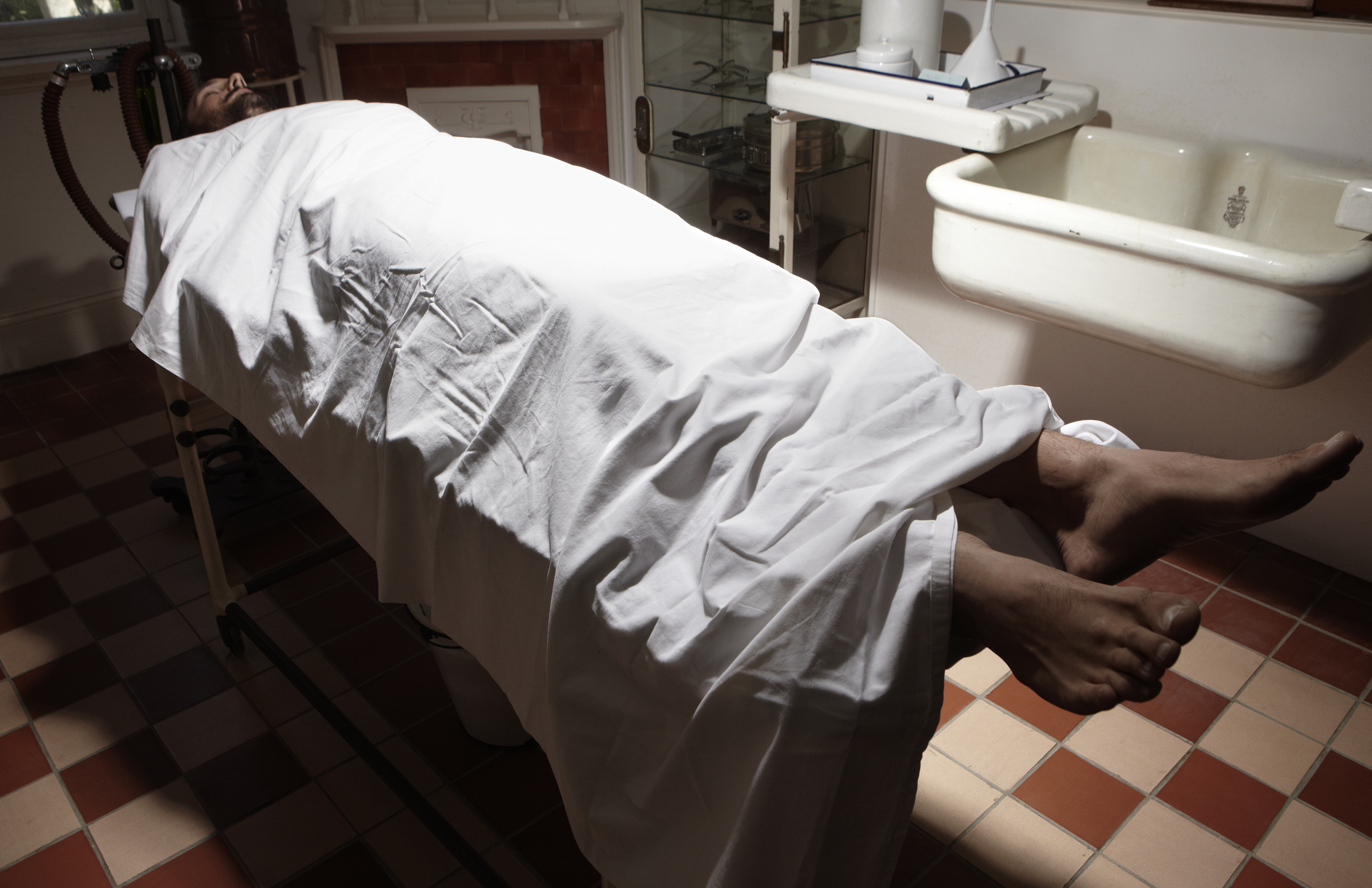 Man lying on operating table in antiquated theatre