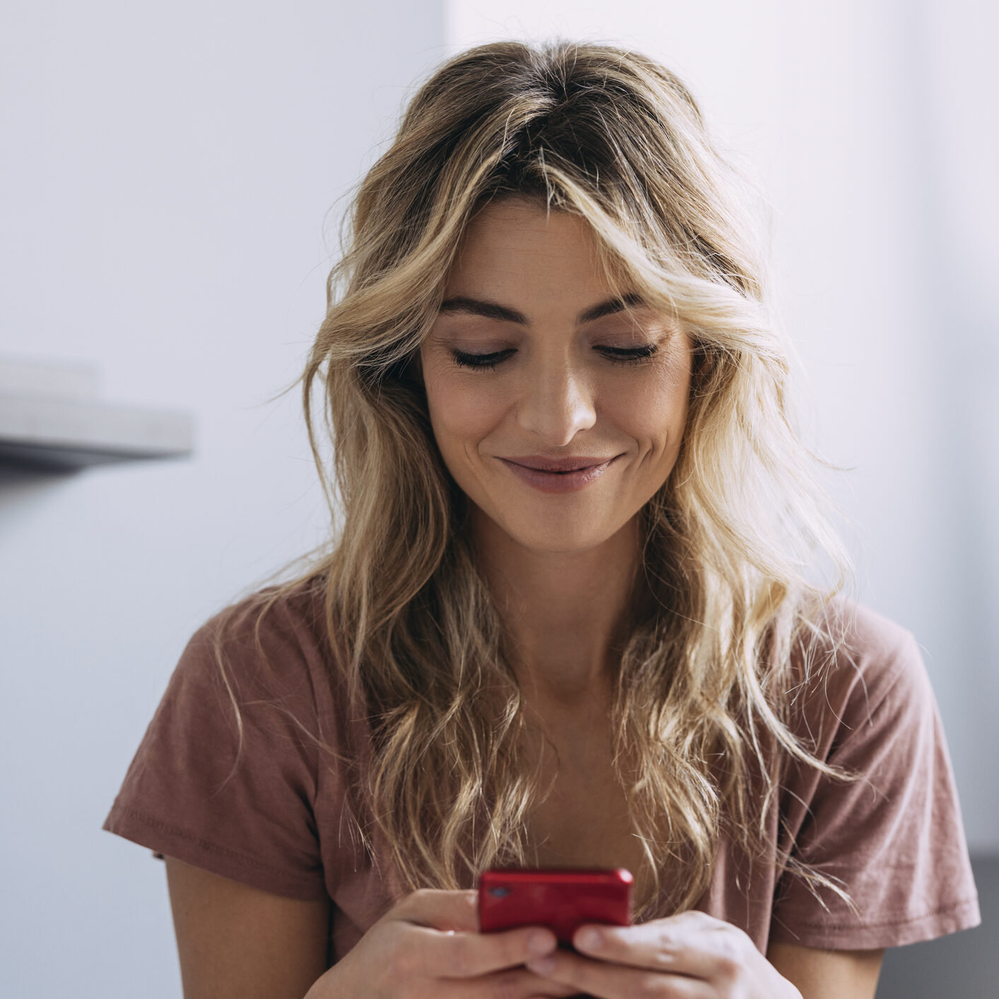 A Blonde Woman Texting And Smiling Pamela Anderson