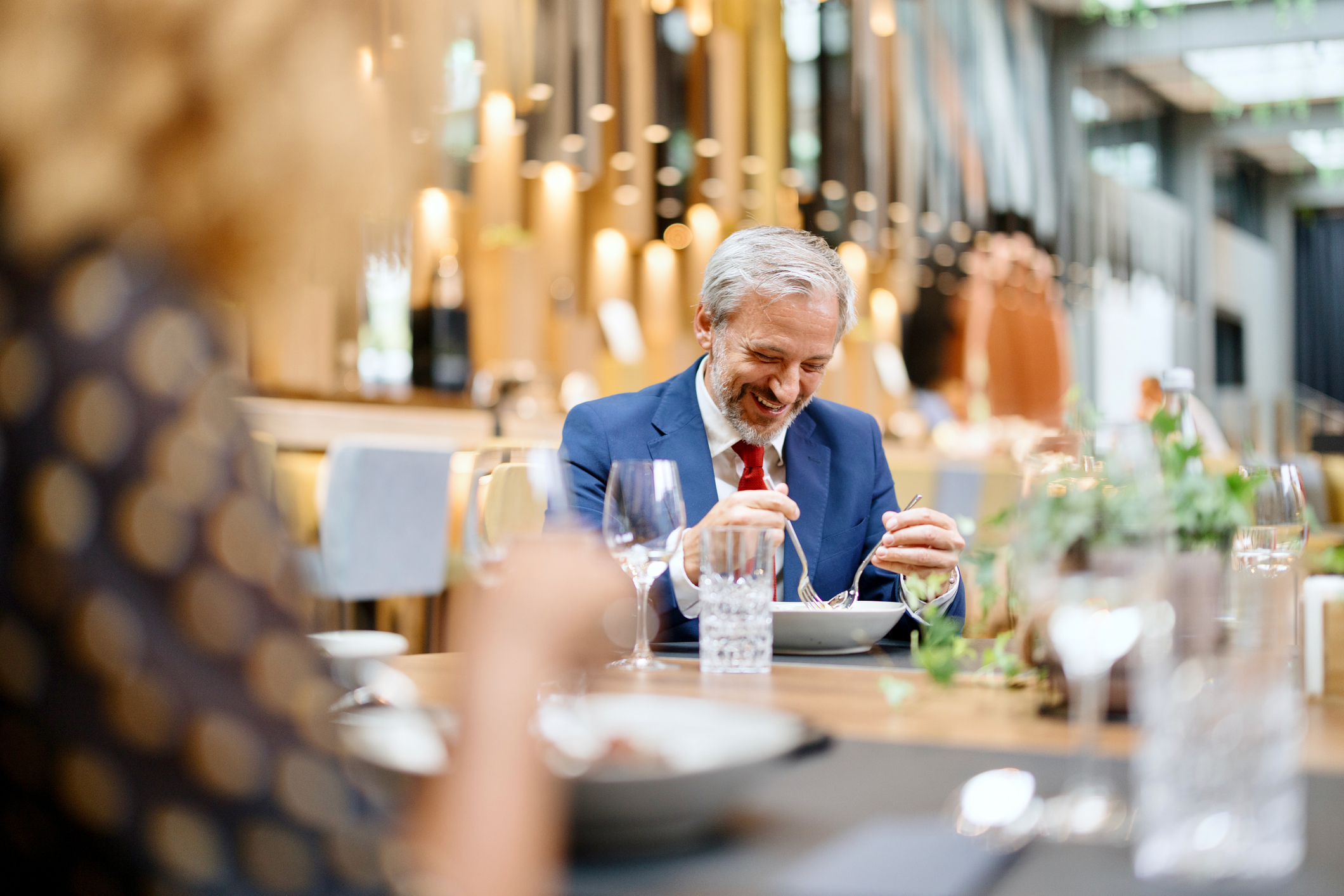 Group of business people communicating while having a business lunch in a high end restaurant. Pamela Anderson