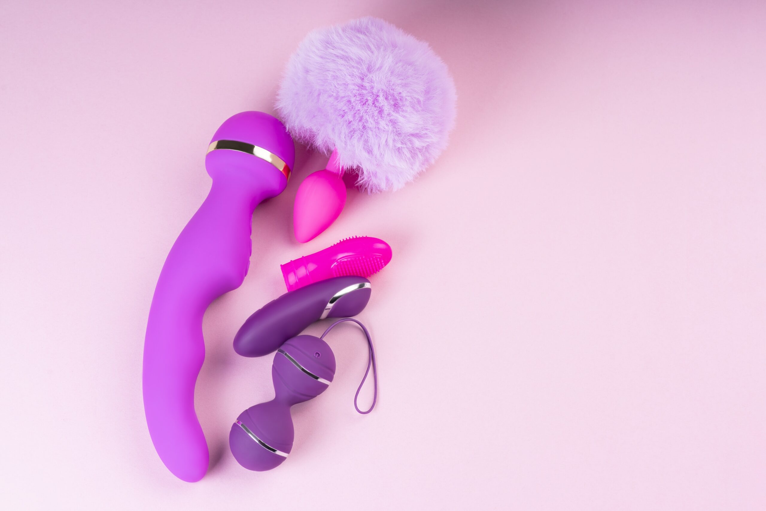 Collection of different types pink of sex toys on pink background. Pamela Anderson