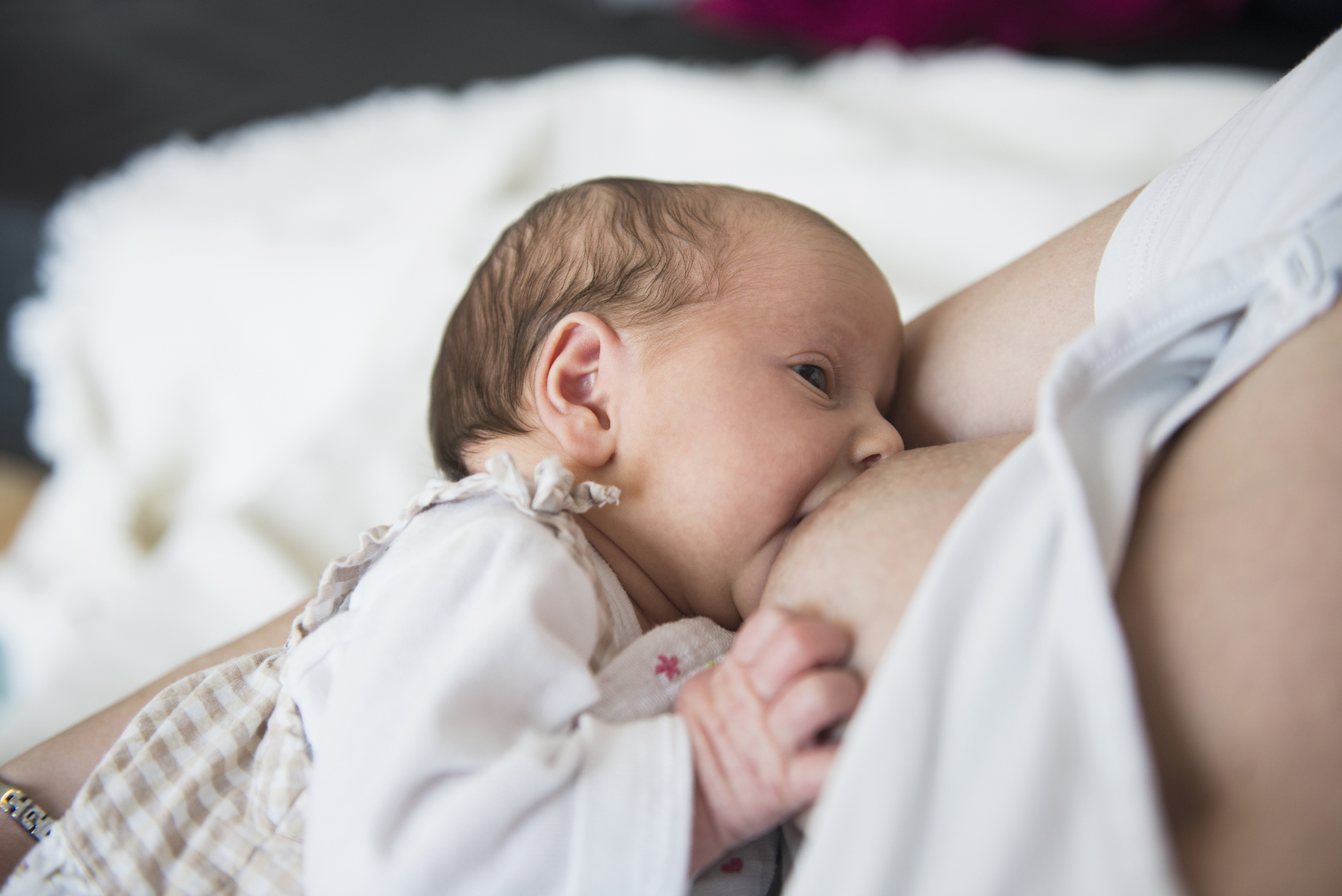 Mother breastfeeding her newborn baby girl.