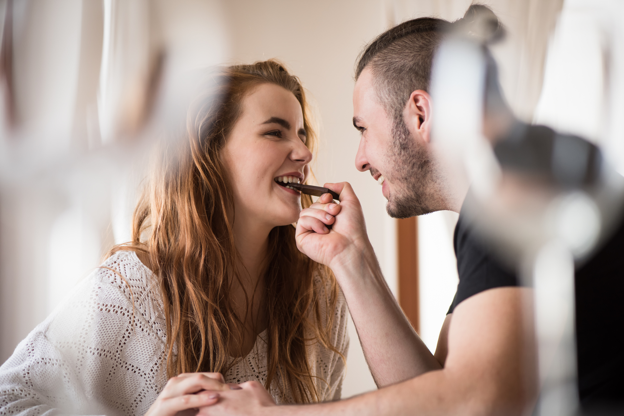 Smiling girlfriend having a bite of chololate Couple eating chocolate