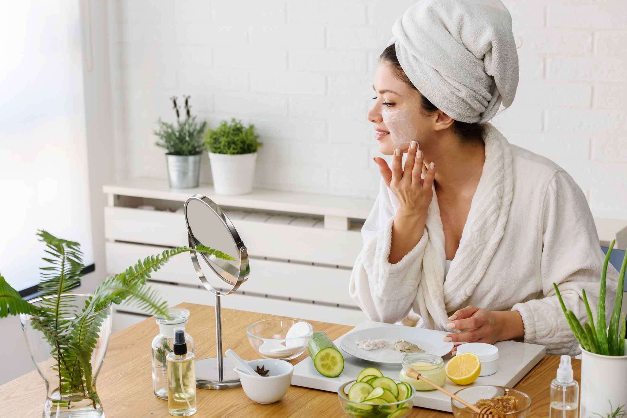 Young woman applying face mask at home. Natural Skin Care Routine For Glowing Skin. Homemade face mask
