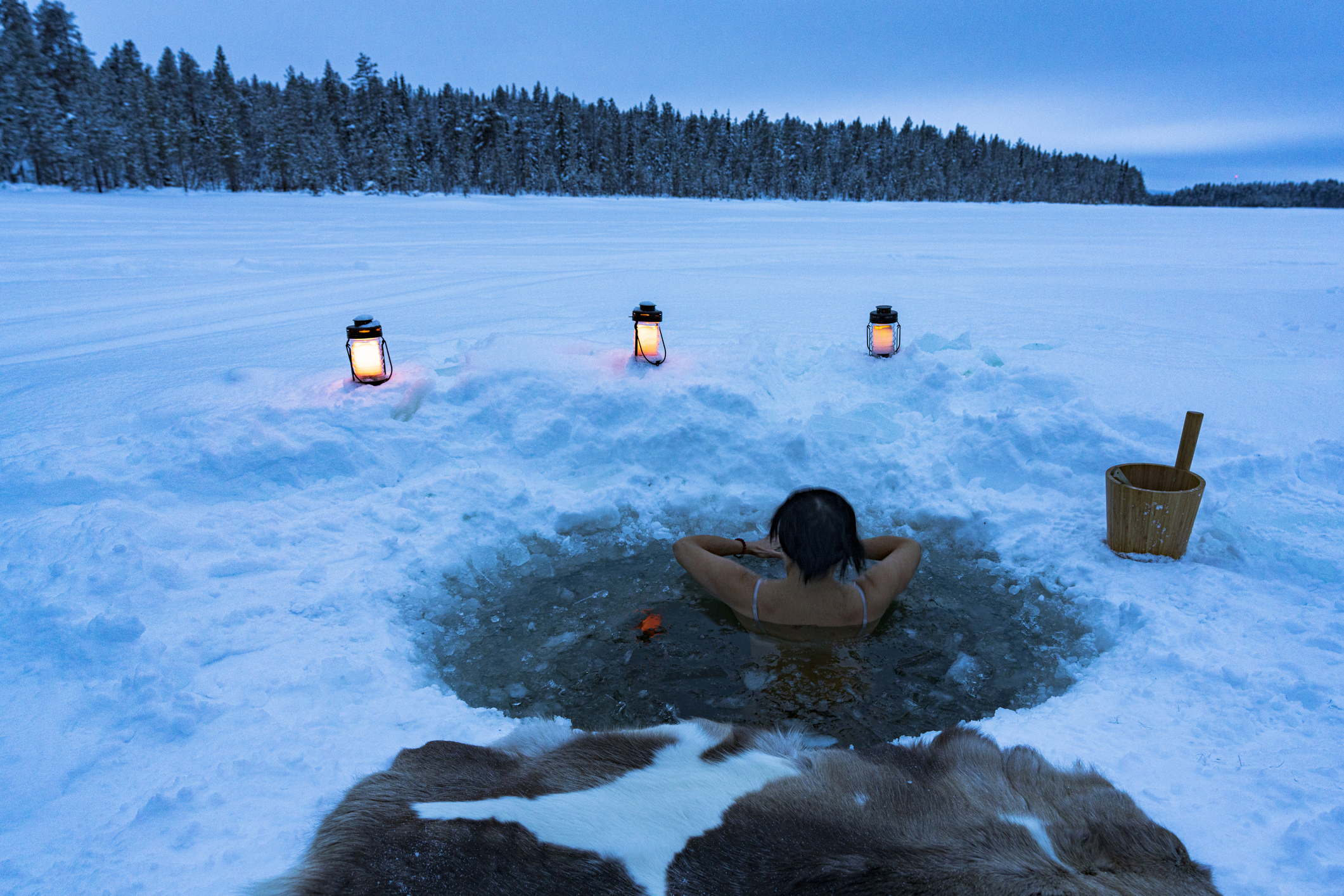 Woman enjoying cold baths in a ice hole, Lapland Ice bath