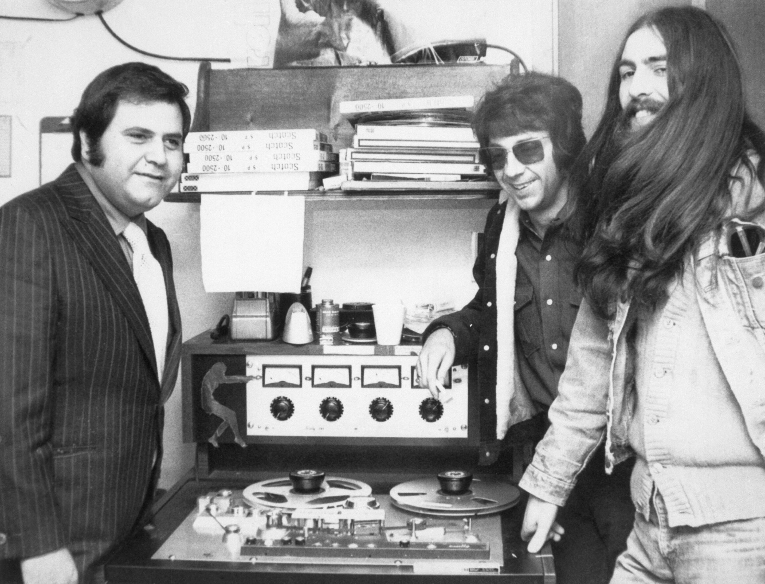 George Harrison, sporting below-the-shoulder-length hair, listens to master tape of his first solo album in recording studio here Cot 30 with Pete Bennett {l} of Apple Records and producer Phil Spector.
