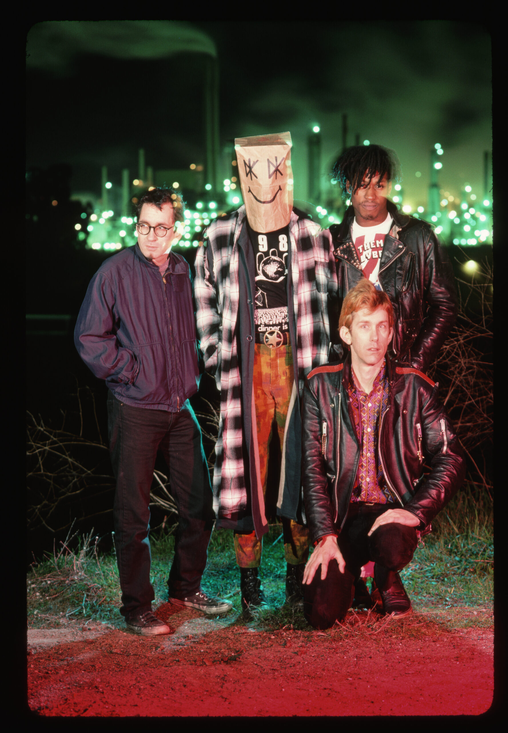 The Dead Kennedys (from left: Klaus Flouride, Jello Biafra, East Bay Ray (kneeling), and D. H. Peligro) pose in front of an oil refinery.